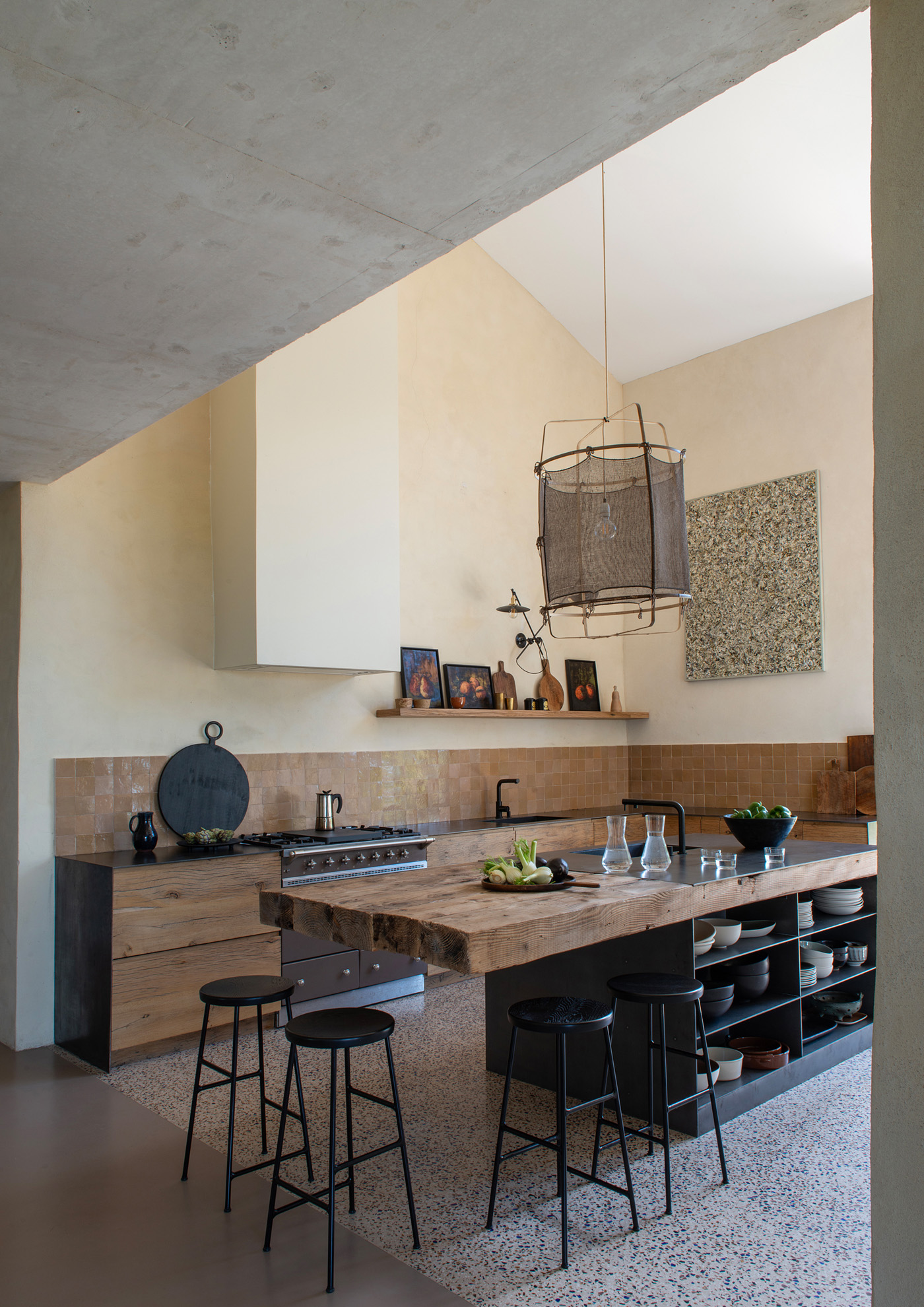 Îlot de cuisine en poutres anciennes et plan de travail en acier. Cuisinière Lacanche. Réalisation Laurent PASSE.
