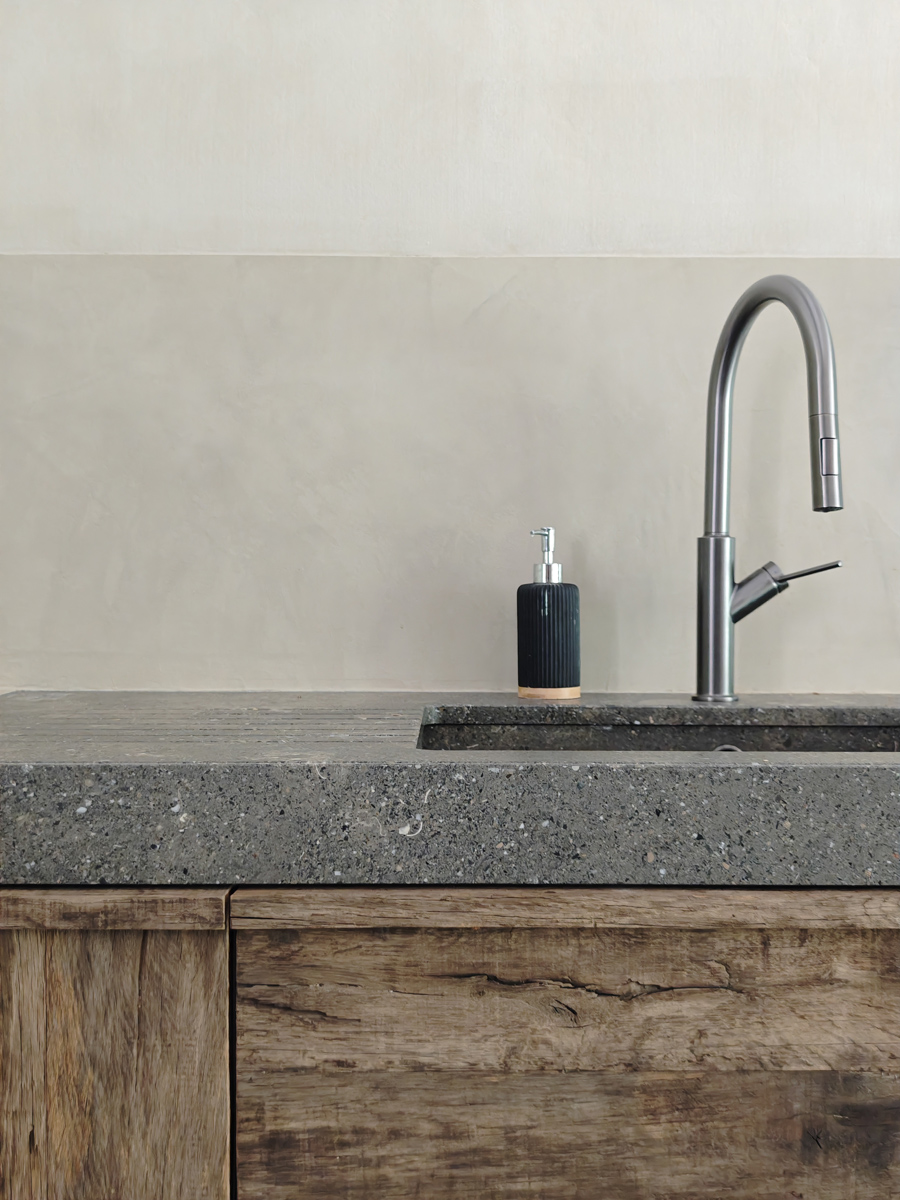 Détail de cuisine avec plan de travail en pierre de san vicente et façade en bois brut.